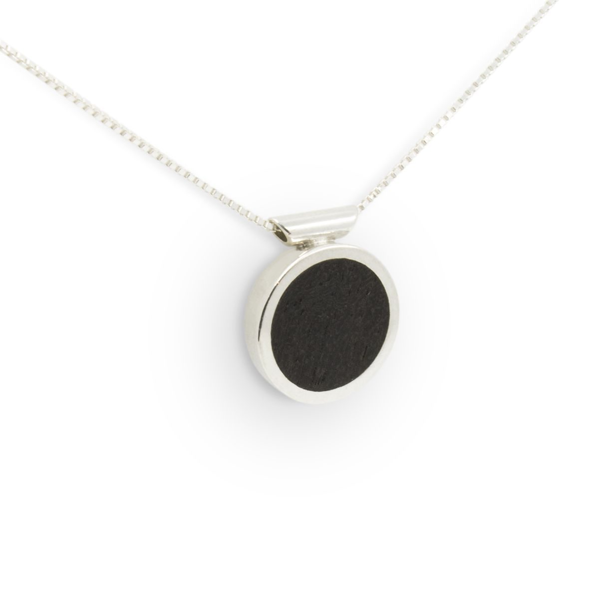 colgante-plata-ebano-cadena-minimalista-diseno-artesaniacontemporanea-casablanca-malicia-2 Colgante de plata 925 con incrustación de madera de ébano. Diámetro 15mm, grosor 4mm. Cadena de plata 925, longitud opcional 40cm, 45cm, o 50cm. Cierre de "reasa" sencillo. Objeto diseñado y fabricado artesanalmente en Madrid, España, por el estudio-taller de malicia. Este colgante ha sido fabricado por personas que disfrutan su trabajo.