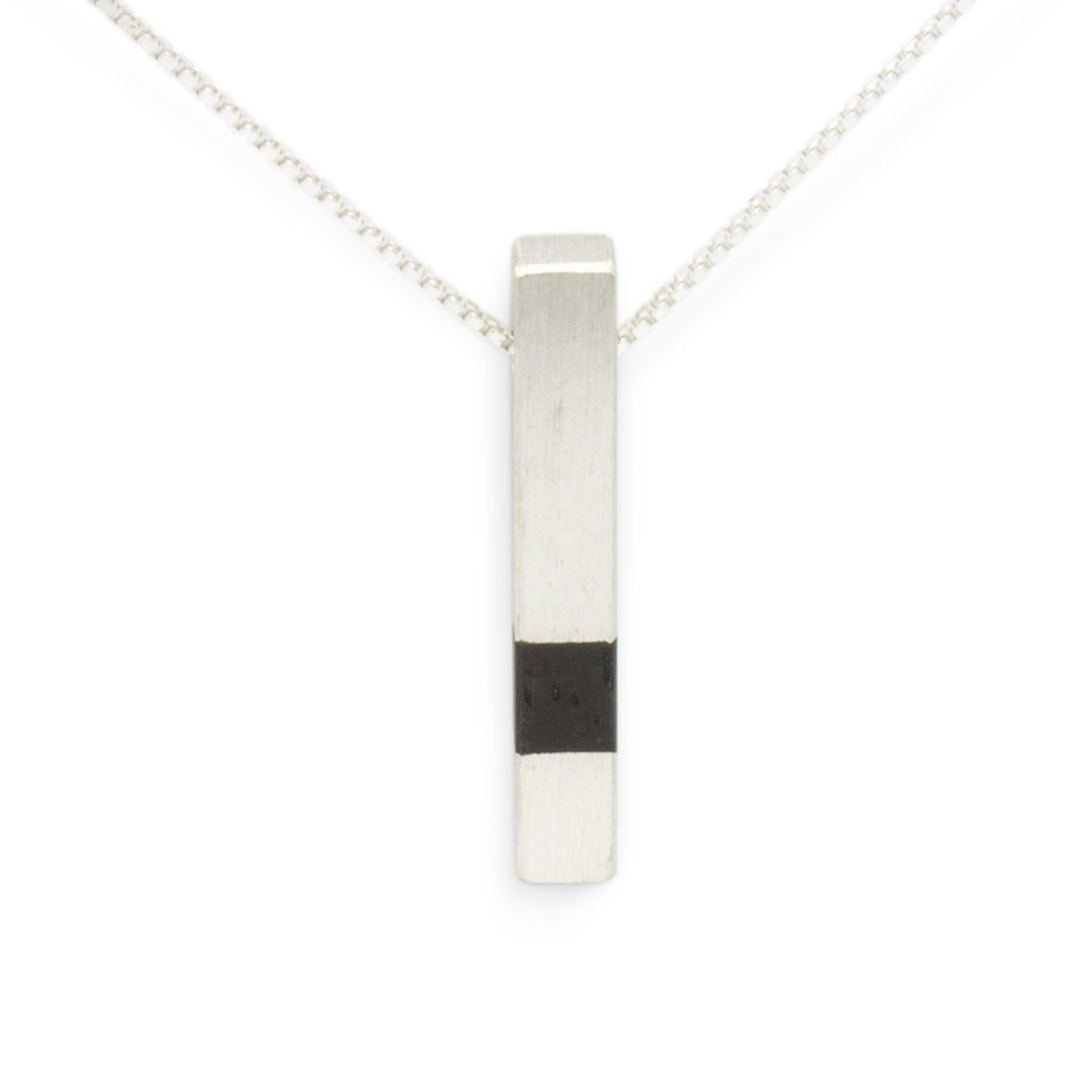 colgante-plata-madera-ebano-minimalismo-diseno-artesaniacontemporanea-casablanca-malicia-1 Colgante de plata 925 mate con incrustación de madera de ébano. Longitud aprox. 30mm. Cadena de plata 925, longitud opcional 40cm, 45cm, o 50cm. Cierre de "reasa" sencillo. Objeto diseñado y fabricado artesanalmente en Madrid, España, por el estudio-taller de malicia. Este colgante ha sido fabricado por personas que disfrutan su trabajo.