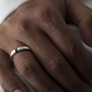 Anillo macizo de plata 925 mate con incrustación de madera de ébano. Anchura 4mm. Interior pulido. Los rebajes laterales lo convierten en un anillo particularmente cómodo, y mantienen la incrustación de ébano en el revés de la mano. Objeto diseñado y fabricado artesanalmente en Madrid, España, por el estudio-taller de malicia. Este anillo ha sido fabricado por personas que disfrutan su trabajo.