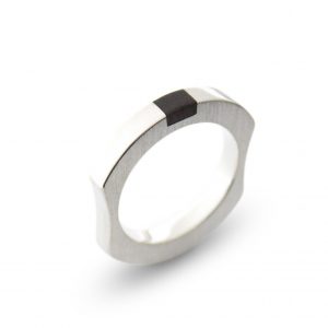 Anillo macizo de plata 925 mate con incrustación de madera de ébano. Anchura 4mm. Interior pulido. Los rebajes laterales lo convierten en un anillo particularmente cómodo, y mantienen la incrustación de ébano en el revés de la mano.